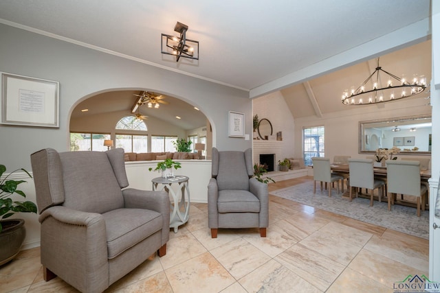 sitting room with ceiling fan, vaulted ceiling, ornamental molding, and a large fireplace