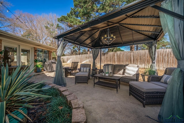 view of patio with a gazebo, an outdoor living space, and fence