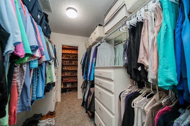 walk in closet with visible vents and light carpet