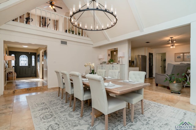 dining space with light tile patterned flooring, visible vents, ceiling fan with notable chandelier, and high vaulted ceiling