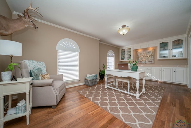 interior space with crown molding, wood finished floors, and baseboards