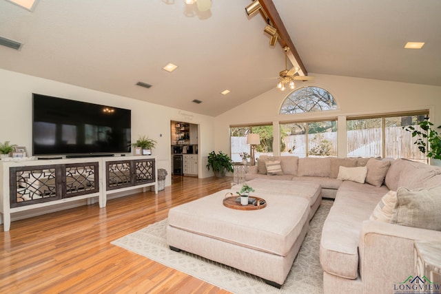 living room featuring ceiling fan, visible vents, beam ceiling, and wood finished floors