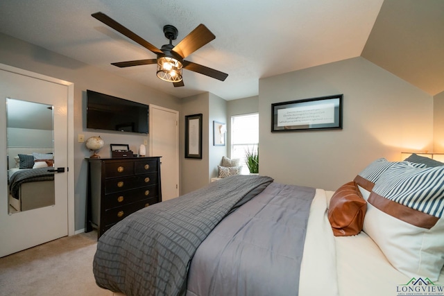 bedroom featuring light colored carpet, a ceiling fan, and vaulted ceiling