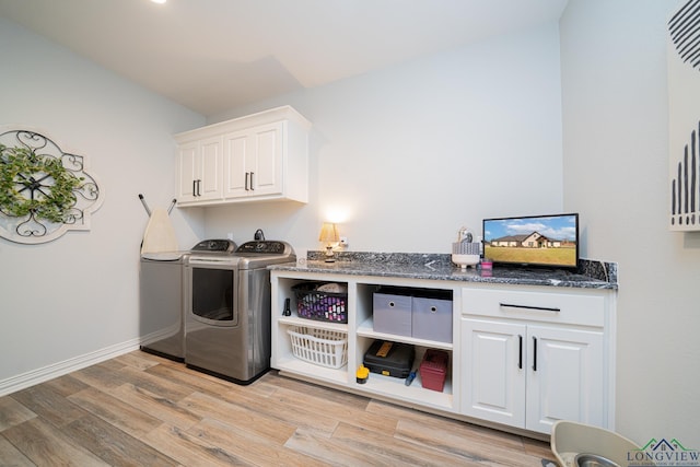 clothes washing area with cabinet space, baseboards, light wood-style floors, and separate washer and dryer