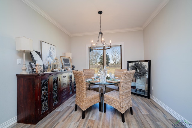 dining space featuring crown molding, baseboards, light wood-type flooring, and an inviting chandelier