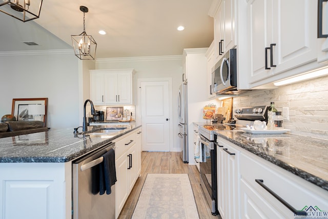 kitchen featuring visible vents, a sink, white cabinets, appliances with stainless steel finishes, and crown molding