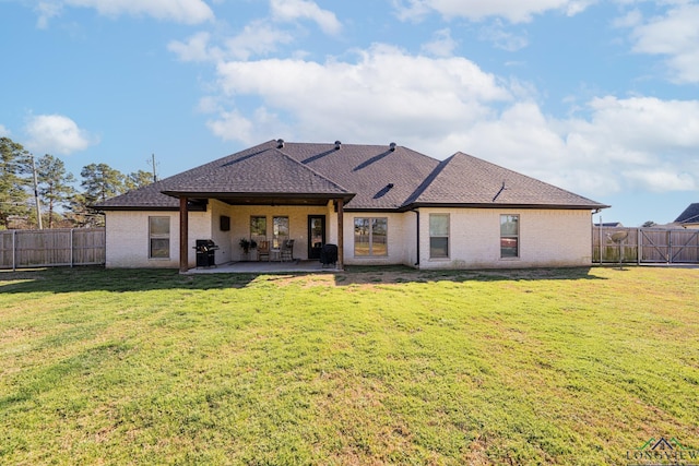 back of house with a yard, a patio area, a fenced backyard, and roof with shingles