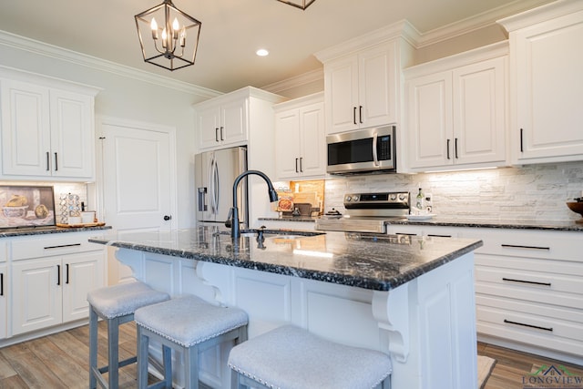 kitchen with a sink, crown molding, light wood-style floors, and stainless steel appliances