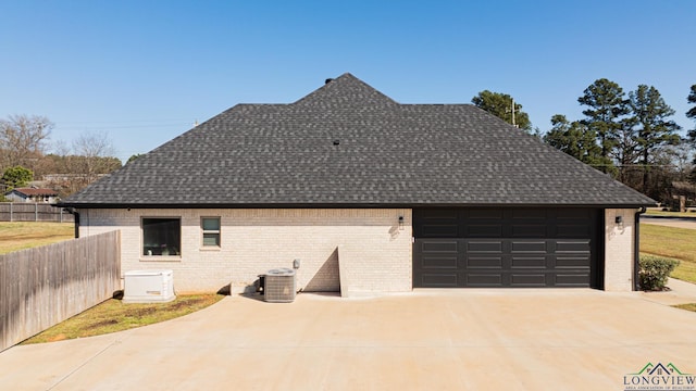 exterior space featuring central AC unit, concrete driveway, and fence