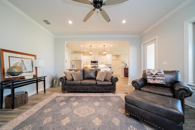 living room with visible vents, light wood-style flooring, recessed lighting, crown molding, and baseboards