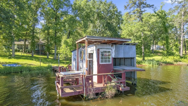 view of dock with a lawn and a water view