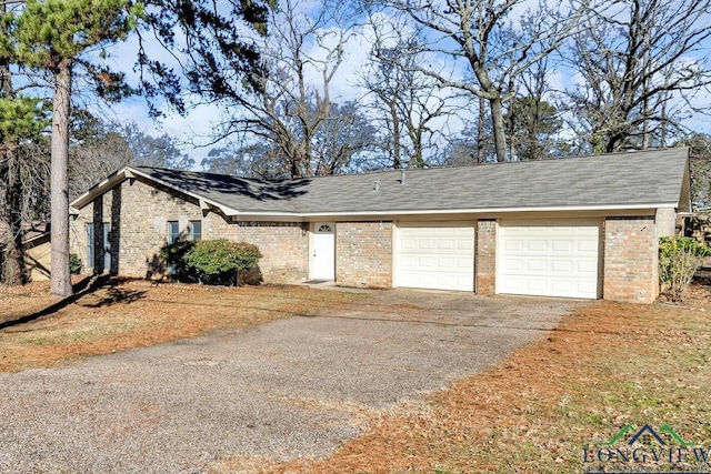 view of front of home with driveway, brick siding, roof with shingles, and an attached garage