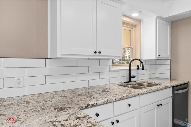 kitchen featuring white cabinetry, sink, backsplash, and light stone counters