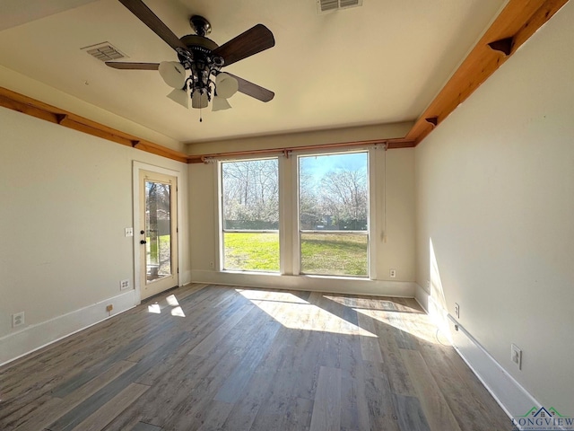 spare room featuring visible vents, ceiling fan, and wood finished floors