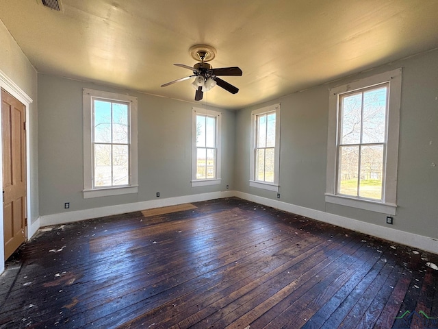 empty room featuring a ceiling fan, baseboards, and wood-type flooring