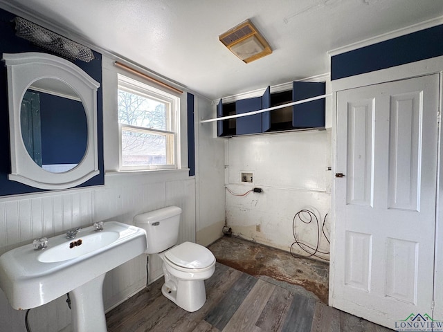 full bath featuring a sink, a wainscoted wall, toilet, and wood finished floors