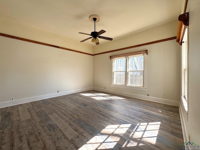 spare room with baseboards, wood finished floors, and a ceiling fan