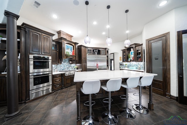 kitchen with visible vents, light countertops, appliances with stainless steel finishes, backsplash, and a warming drawer