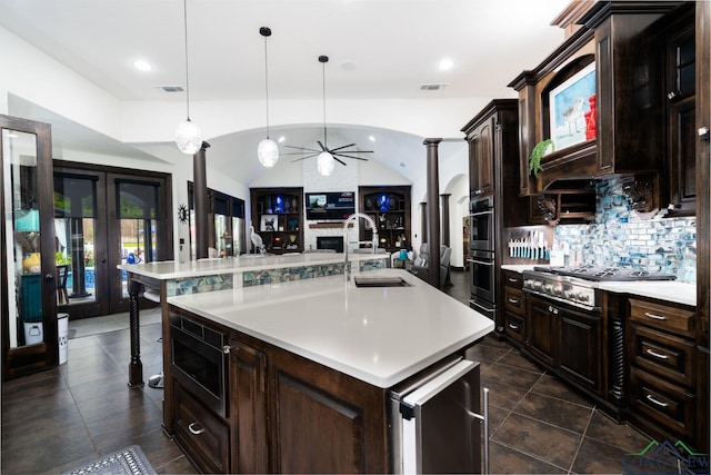 kitchen with a ceiling fan, vaulted ceiling, stainless steel appliances, light countertops, and backsplash