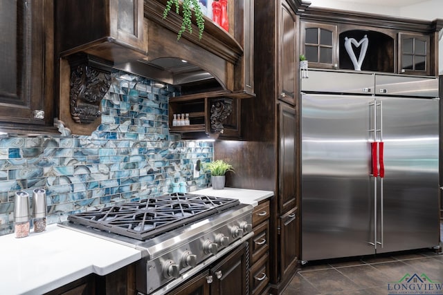 kitchen featuring stainless steel appliances, light countertops, dark brown cabinetry, and decorative backsplash