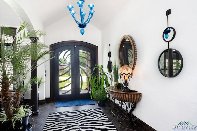 foyer entrance with arched walkways, french doors, vaulted ceiling, tile patterned flooring, and baseboards