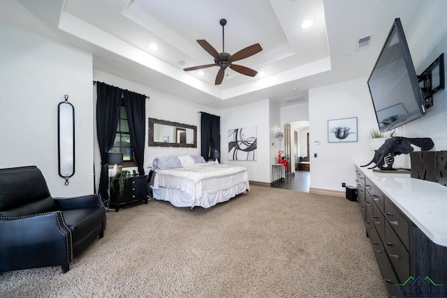 bedroom featuring light carpet, visible vents, arched walkways, a raised ceiling, and baseboards