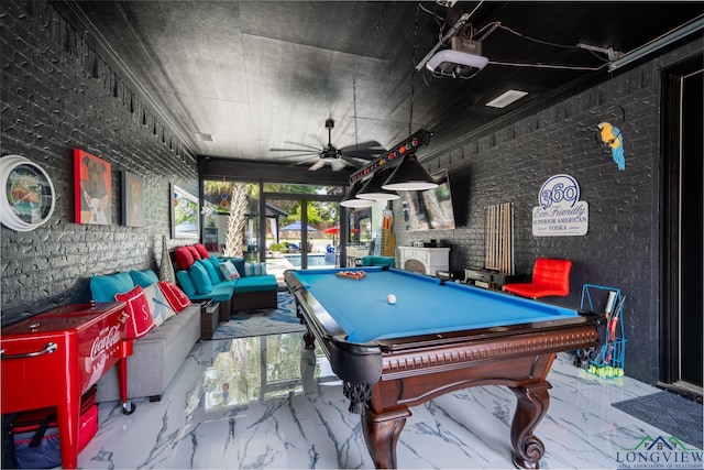 playroom featuring marble finish floor, pool table, and brick wall