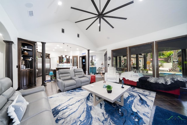 tiled living room featuring visible vents, arched walkways, a ceiling fan, ornate columns, and high vaulted ceiling