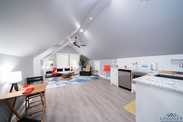 recreation room with lofted ceiling, light wood-style flooring, a sink, visible vents, and a ceiling fan