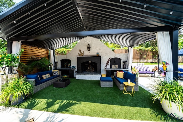 view of patio / terrace featuring an outdoor living space with a fireplace and fence