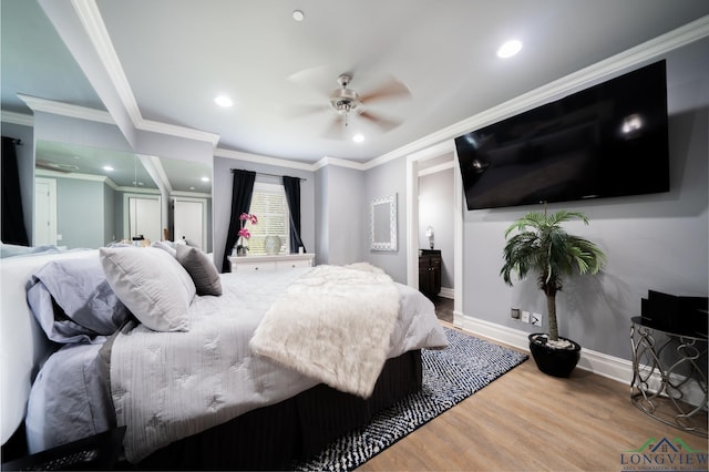 bedroom with recessed lighting, ornamental molding, ensuite bath, wood finished floors, and baseboards