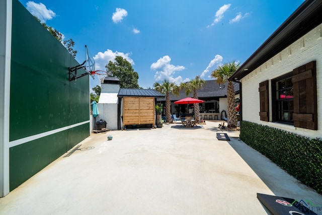 view of patio featuring a shed, outdoor dining area, and an outdoor structure