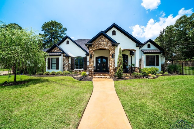 view of front of property featuring a standing seam roof, fence, a front lawn, and french doors