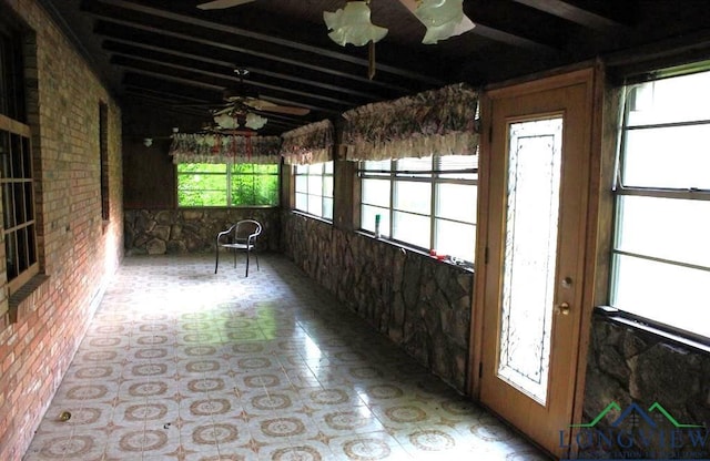 unfurnished sunroom with ceiling fan