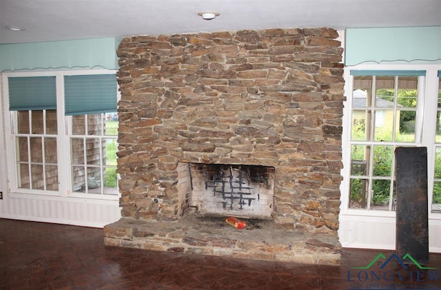 interior details with parquet floors and a stone fireplace