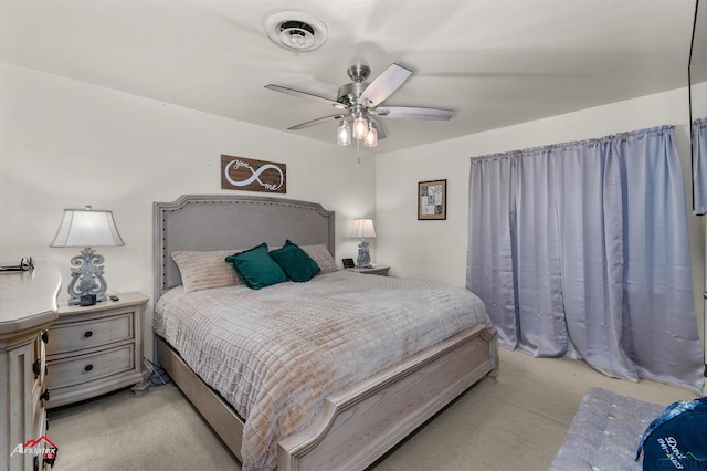 bedroom with light colored carpet and a ceiling fan
