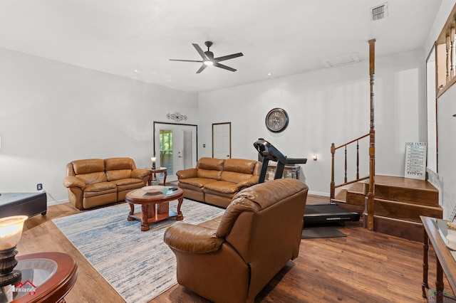 living room featuring ceiling fan, wood finished floors, and stairway