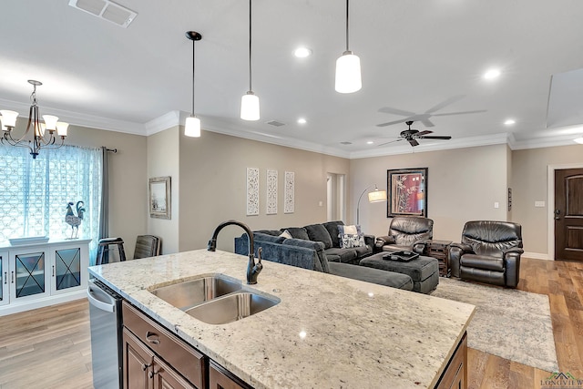 kitchen with a sink, open floor plan, dishwasher, light wood finished floors, and visible vents