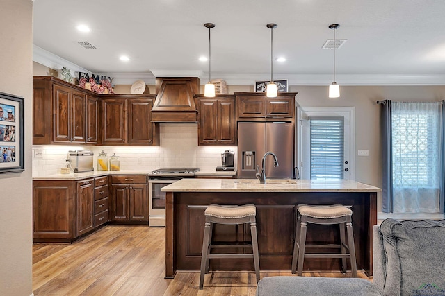 kitchen featuring ornamental molding, stainless steel appliances, visible vents, and custom range hood