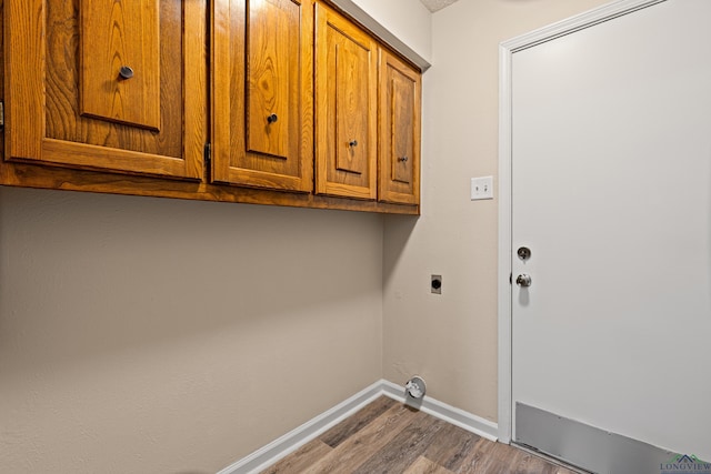 1001 Towne Lake Dr, Longview, TX 75601 - laundry room with hookup for an electric dryer, wood finished floors, and cabinet space