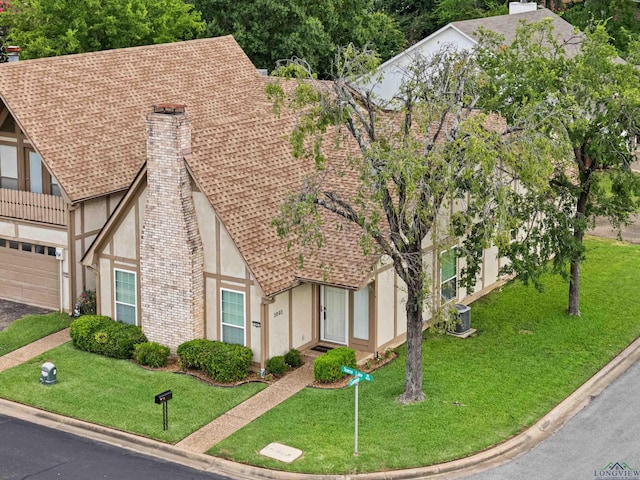 1001 Towne Lake Dr, Longview, TX 75601 - english style home with a chimney, stucco siding, roof with shingles, and a garage