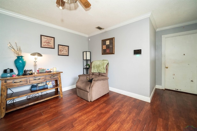 sitting room featuring dark wood-type flooring, ceiling fan, and crown molding