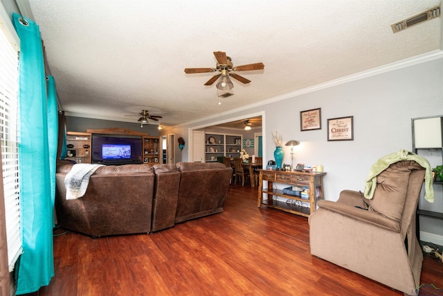 living room with ceiling fan, crown molding, dark wood-type flooring, and a textured ceiling