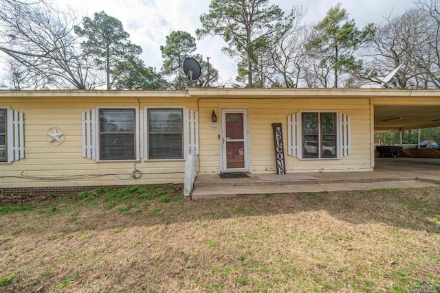 view of front of property featuring a front yard and a carport