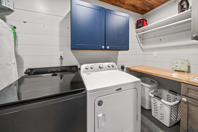 13391 County Road 4336, Larue, TX 75770 - clothes washing area featuring cabinet space, washer and clothes dryer, and wood walls