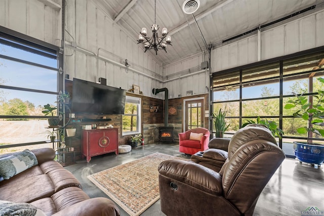 13391 County Road 4336, Larue, TX 75770 - living area featuring concrete flooring, high vaulted ceiling, a wood stove, and a chandelier