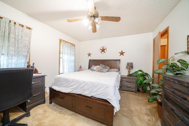 bedroom featuring ceiling fan, light colored carpet, and a textured ceiling