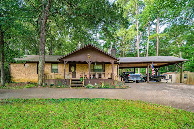 view of front of property with a carport, a porch, a storage shed, and a front yard