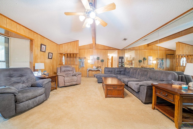 carpeted living room featuring ceiling fan, lofted ceiling with beams, and a textured ceiling