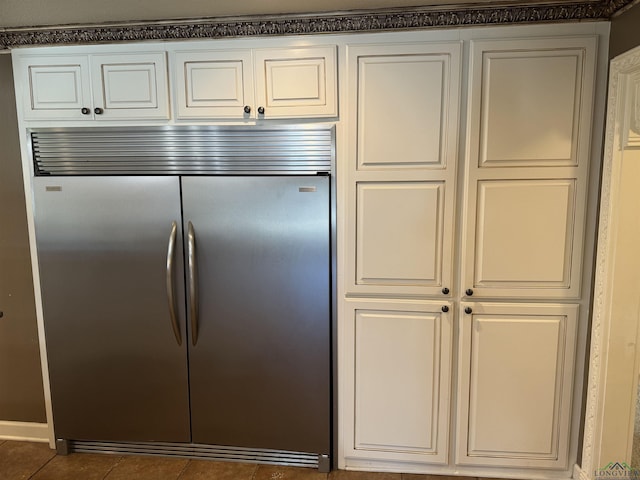 kitchen with stainless steel built in fridge and dark tile patterned floors